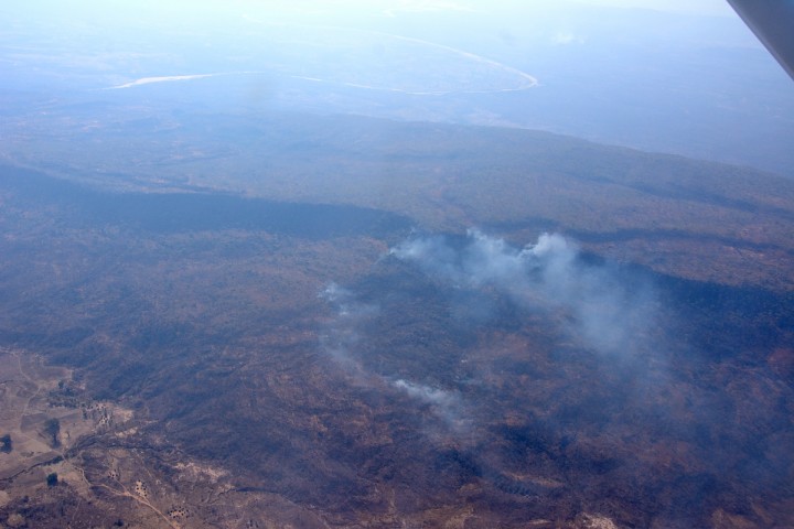 The landscape is shrouded in a haze of smoke and dust